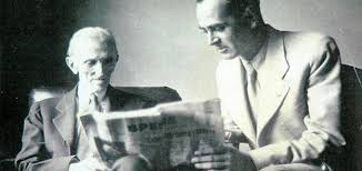Historical photo of Nikola Tesla and a companion reading a newspaper